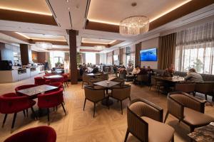 ein Restaurant mit Menschen, die an Tischen und Stühlen sitzen in der Unterkunft Hotel Mozart in Shkodra