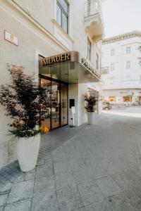 a large building with a sign that reads mauzer at IMLAUER Palais Mirabell in Salzburg