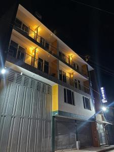 a large white building with a balcony at night at Hotel Olam Confort in Villavicencio +34 photos