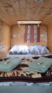 a bed in a wooden room with two pillows on it at GeghardCamping in Goghtʼ