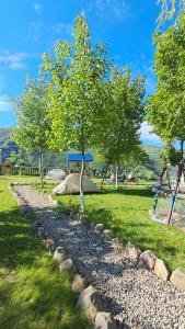 a stone path in a park with trees and a playground at GeghardCamping in Goghtʼ +40 photos