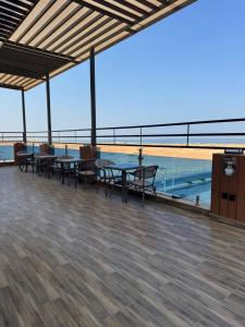 a deck with tables and chairs and a view of the ocean at فندق ايلانا بلس in Farasan