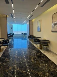 a conference room with tables and chairs and a glass floor at فندق ايلانا بلس in Farasan