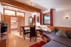 a living room with a table and a couch at Klausnerhof in Aschau