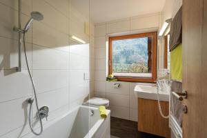 a bathroom with a tub and a toilet and a sink at Klausnerhof in Aschau +99 photos