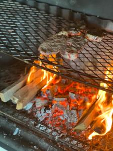 a grill with some food cooking on fire at The Schoolhouse at Meulplaas in Montagu
