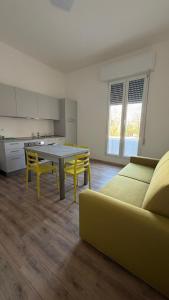 a living room with a table and a yellow couch at Apppartamenti La Fiorentina 609 in Gagno