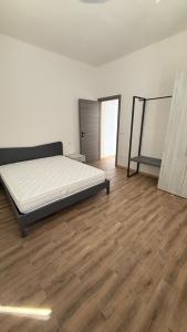 a white room with a bed and a wooden floor at Apppartamenti La Fiorentina 609 in Gagno