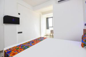 a bedroom with a bed with a colorful bedspread at FabHotel DSP in Pune