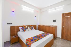 a bedroom with a bed and a wooden cabinet at FabHotel DSP in Pune