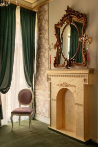 a mirror and a chair in a room with a fireplace at Belle Epoque Boutique (Adult Only) in Constanţa