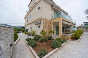 a house with a walkway in front of it at Asini deluxe suite 1, with rooftop terrace and breathtaking views in Asíni