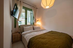 a bedroom with a bed and a television in it at Asini deluxe suite 1, with rooftop terrace and breathtaking views in Asíni
