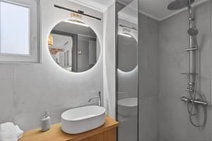 a bathroom with a sink and a mirror at Celeste Syros Retreat in Vári +28 photos