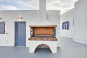 a fireplace in a white room with a blue door at Celeste Syros Retreat in Vári