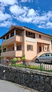 a house with a car parked in front of it at Apartman Natali in Buzdohanj
