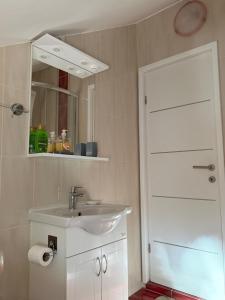 a white bathroom with a sink and a mirror at Mare in Generalski Stol +10 photos