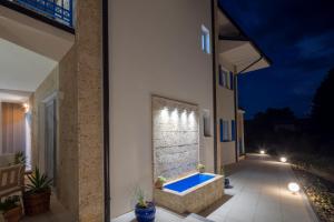 a house with a bathtub on a patio at night at Artemis Escape Suites Srebrno Jezero in Veliko Gradište