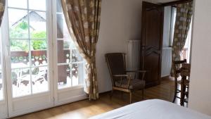 a bedroom with a bed and a window and a chair at Auberge Du Roselet in Duingt +16 photos