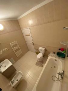 a bathroom with a tub and a toilet and a sink at Cozy Appartement Mahdia in Mahdia