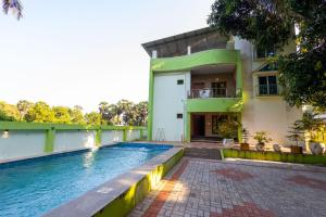 a house with a swimming pool in front of a house at FM Villa Auroville in Pondicherry