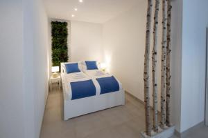 a bedroom with a bed with blue and white sheets at Artemis Escape Suites Srebrno Jezero in Veliko Gradište +80 photos