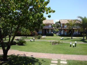 a park in front of a house with a tree at A Casa - com 3 quartos e até 7 Hóspedes in Búzios