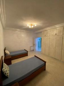 a bedroom with two beds and cabinets in a room at Cozy Appartement Mahdia in Mahdia