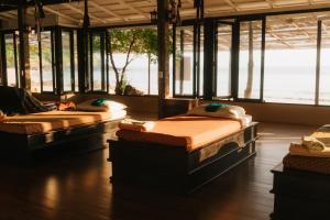 three beds sitting in a room with windows at Anda Lanta Resort in Ko Lanta