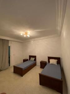 a bedroom with two beds and a ceiling at Cozy Appartement Mahdia in Mahdia