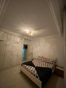 a bedroom with a bed in a room with a ceiling at Cozy Appartement Mahdia in Mahdia