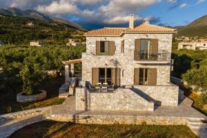 an aerial view of a stone house with mountains in the background at Sofia's Villa in Riglia