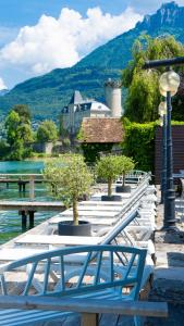 a row of white benches with trees on a dock at Auberge Du Roselet in Duingt