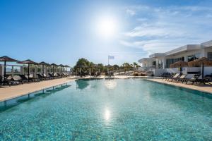 a large swimming pool with chairs in a resort at Akti Dimis Hotel in Tigaki +35 photos