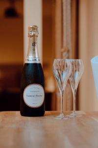a bottle of champagne and two glasses on a table at Suite la Penida avec Sauna & Baignoire - Hyper Centre Lille in Lille +11 photos