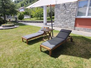 two lounge chairs and a table with an umbrella at Casa Paolina in Premeno