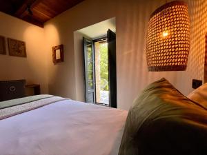 a bedroom with a white bed and a window at Casa Corbeiras Apartamento 1 in A Pontenova