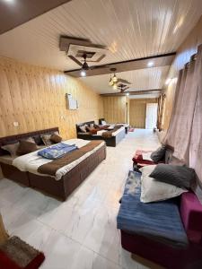 a large room with two beds and a couch at Valley King Resort in Mohan Chatti