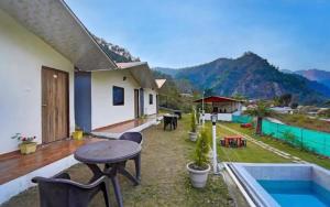 a balcony of a house with a table and chairs at Valley King Resort in Mohan Chatti
