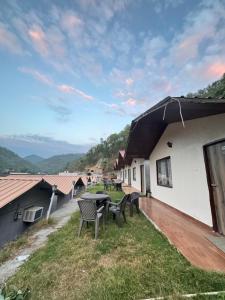 a patio with a table and chairs on the side of a building at Valley King Resort in Mohan Chatti +22 photos