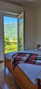 a bedroom with a bed and a large window at Casa Vacanza GERONIMI in San Cassiano