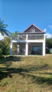 a large white house with a large yard at Chez Pack et Ibu in Petite Île