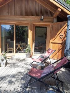 two chairs sitting on a deck in front of a cabin at Petit chalet indépendant 2 pers "La cabane de Jean " in Briançon