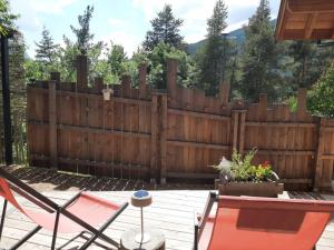 a wooden fence in a yard with a patio at Petit chalet indépendant 2 pers "La cabane de Jean " in Briançon
