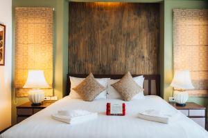a bedroom with a large white bed with two lamps at Anda Lanta Resort in Ko Lanta +46 photos