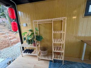 a small house with wooden shelves with plants in it at Fish Farm Uncle Thanh in Xóm Soi (1)