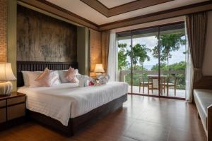 a bedroom with a large bed and a balcony at Anda Lanta Resort in Ko Lanta