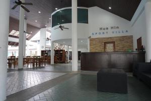a lobby with a restaurant with a sign that reads her him sport villa at Sport Villa Condo in Hua Hin