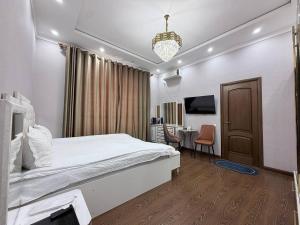 a bedroom with a bed and a desk with a chair at Soro Hotel in Dushanbe +85 photos