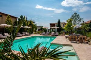 a swimming pool with lounge chairs and umbrellas at Mamaia Moments Villa, Mamaia Nord in Mamaia Sat/Năvodari